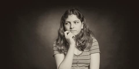 Sepia-toned studio portrait against a dark mottled backdrop, an example of the 1980s mall portrait style